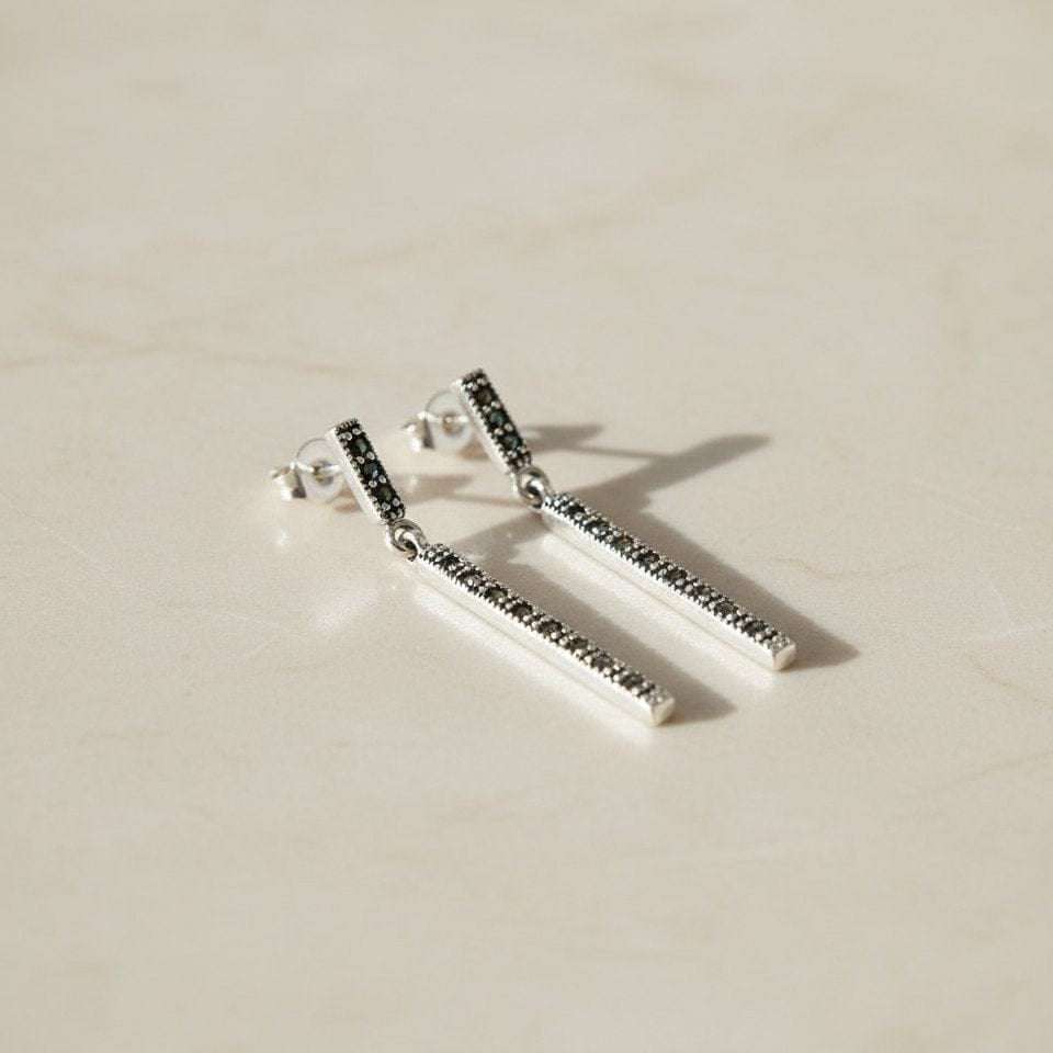 Nachhaltige Abendessen-Silber-Ohrringe aus 925 Sterling mit Markasit, flach auf hellem Steinboden arrangiert für edle Produktpräsentation.